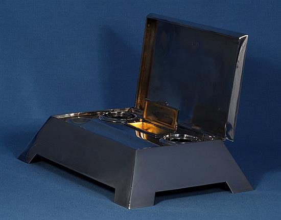 A stylish Edwardian silver inkstand with hinged cover, by length approx 11 ½”/292mm depth 7 ¾”/197 mm. Weight 57ozs/1613grms.